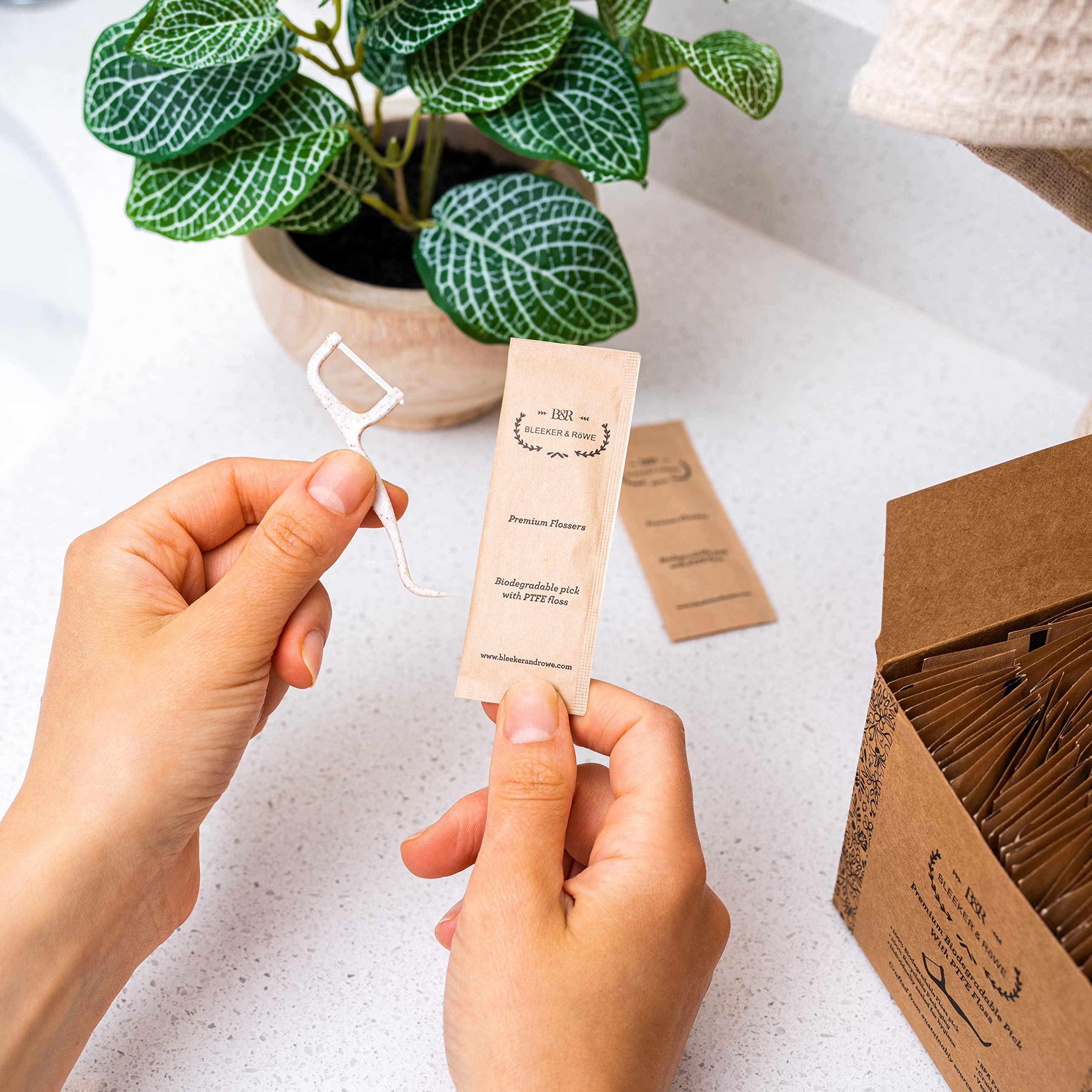 Eco-friendly floss picks displayed with recyclable packaging