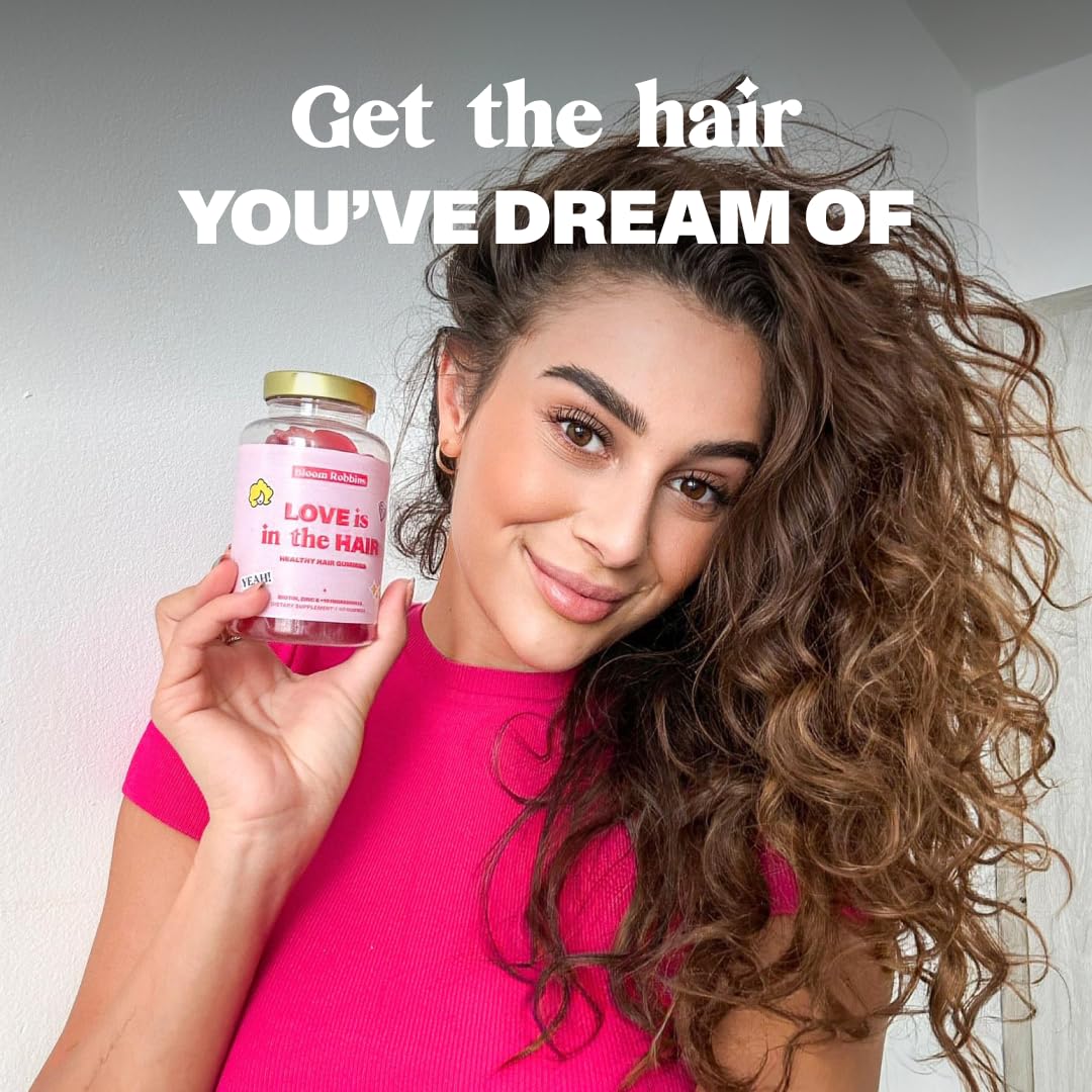 Woman with healthy hair holding Bloom Robbins gummies