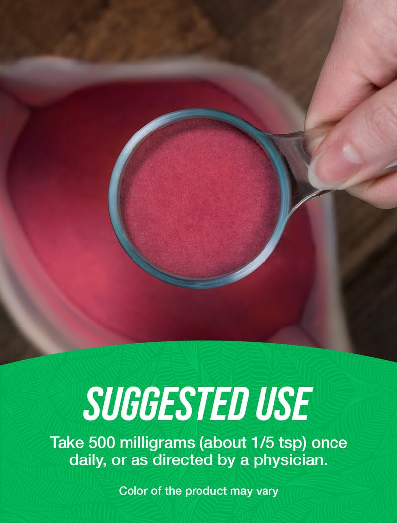 Crushed cranberry extract powder being poured from a scoop