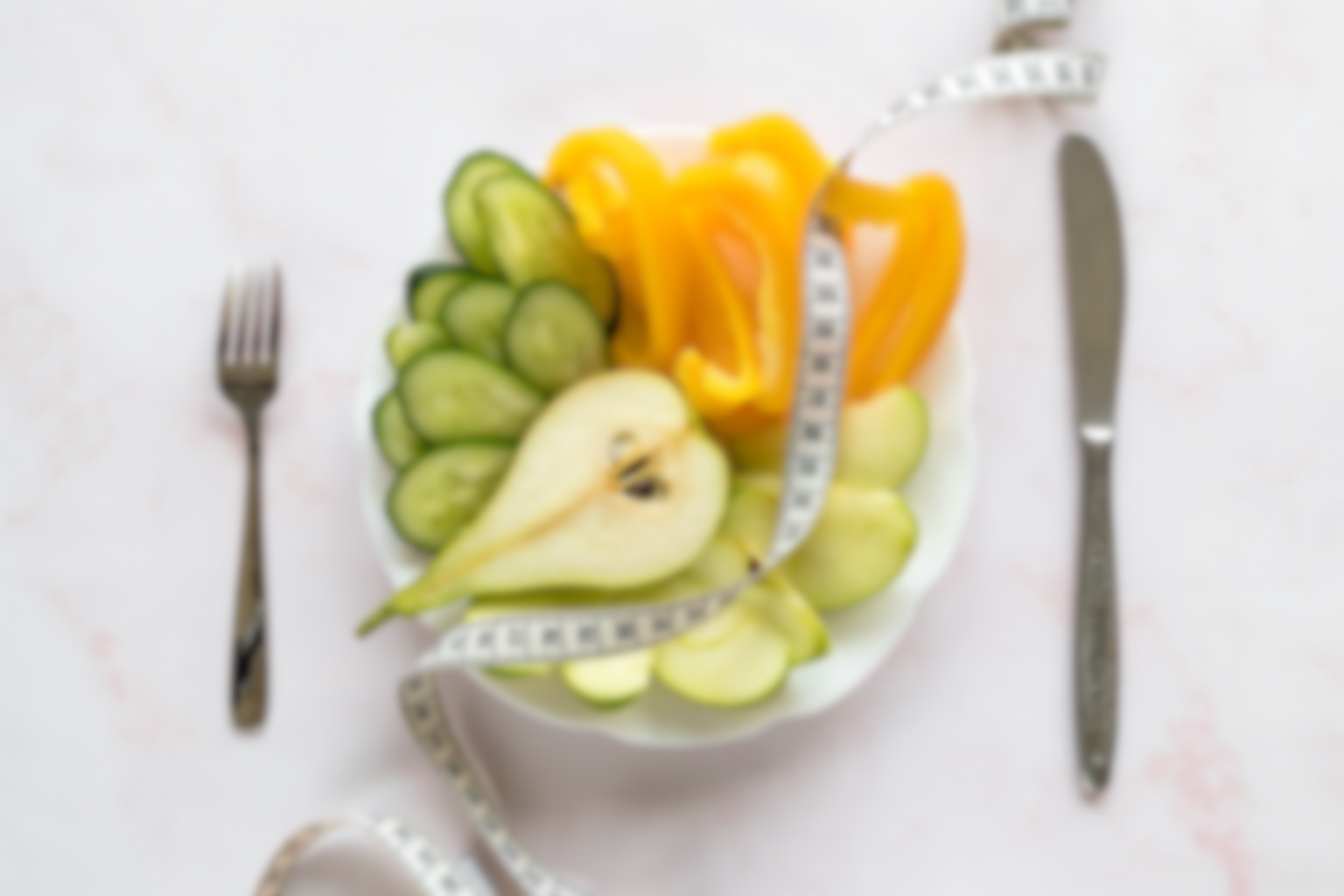 Fruit salad on a plate with a measuring tape, symbolizing healthy eating and weight management.
