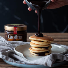 Caotina powder being stirred into a glass of milk