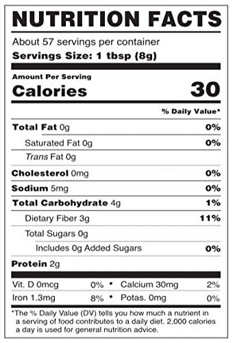 Wheatgrass powder beside a glass of smoothie and greens