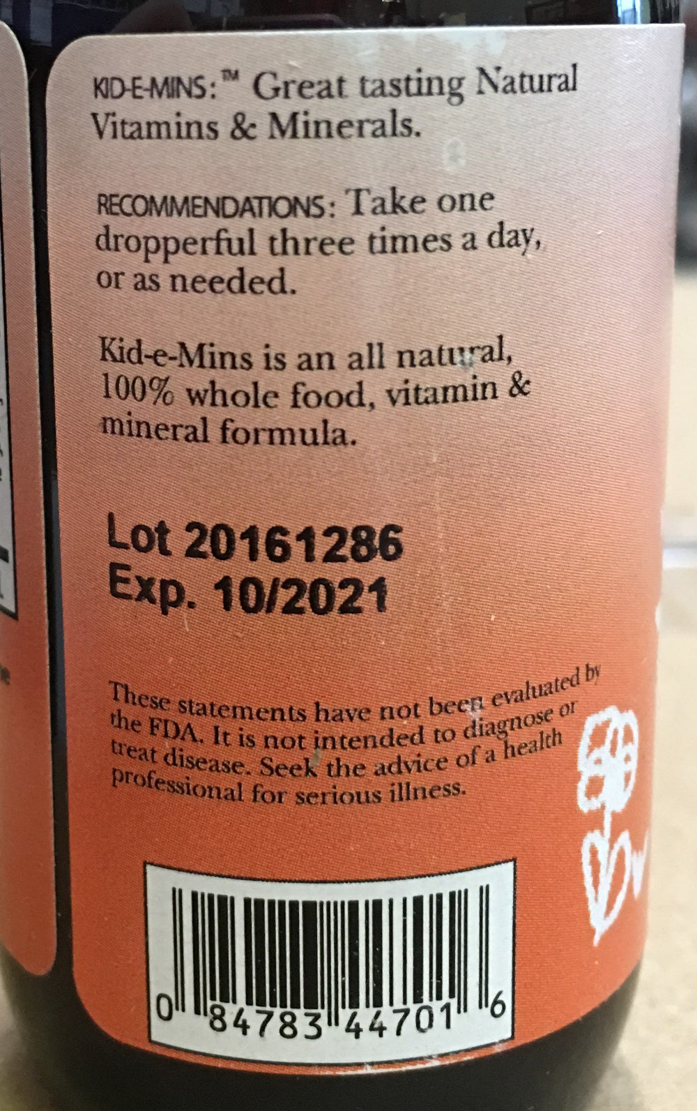 Close-up of Kid-E-Mins orange-flavored liquid multivitamin bottle label