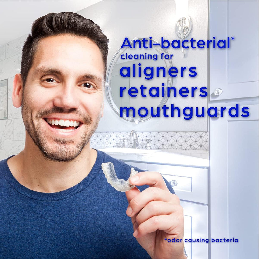 Aligner, retainer, and mouthguard being cleaned with Crest tablets