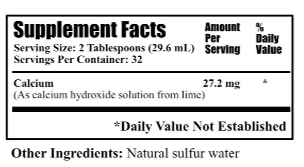 Measuring two tablespoons of Daily's Lime Water for calcium dosage