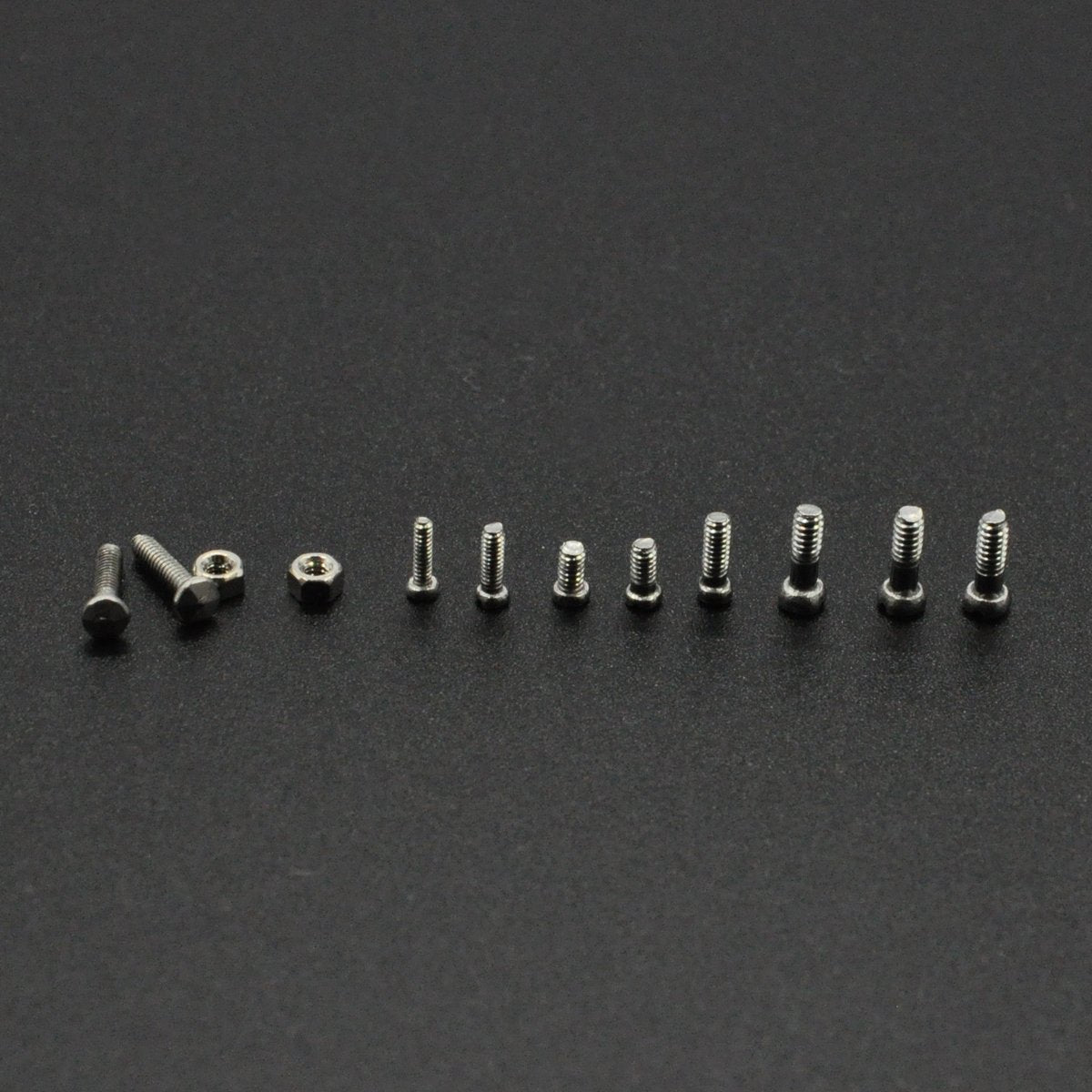 Close-up of micro screws and nuts in a transparent box