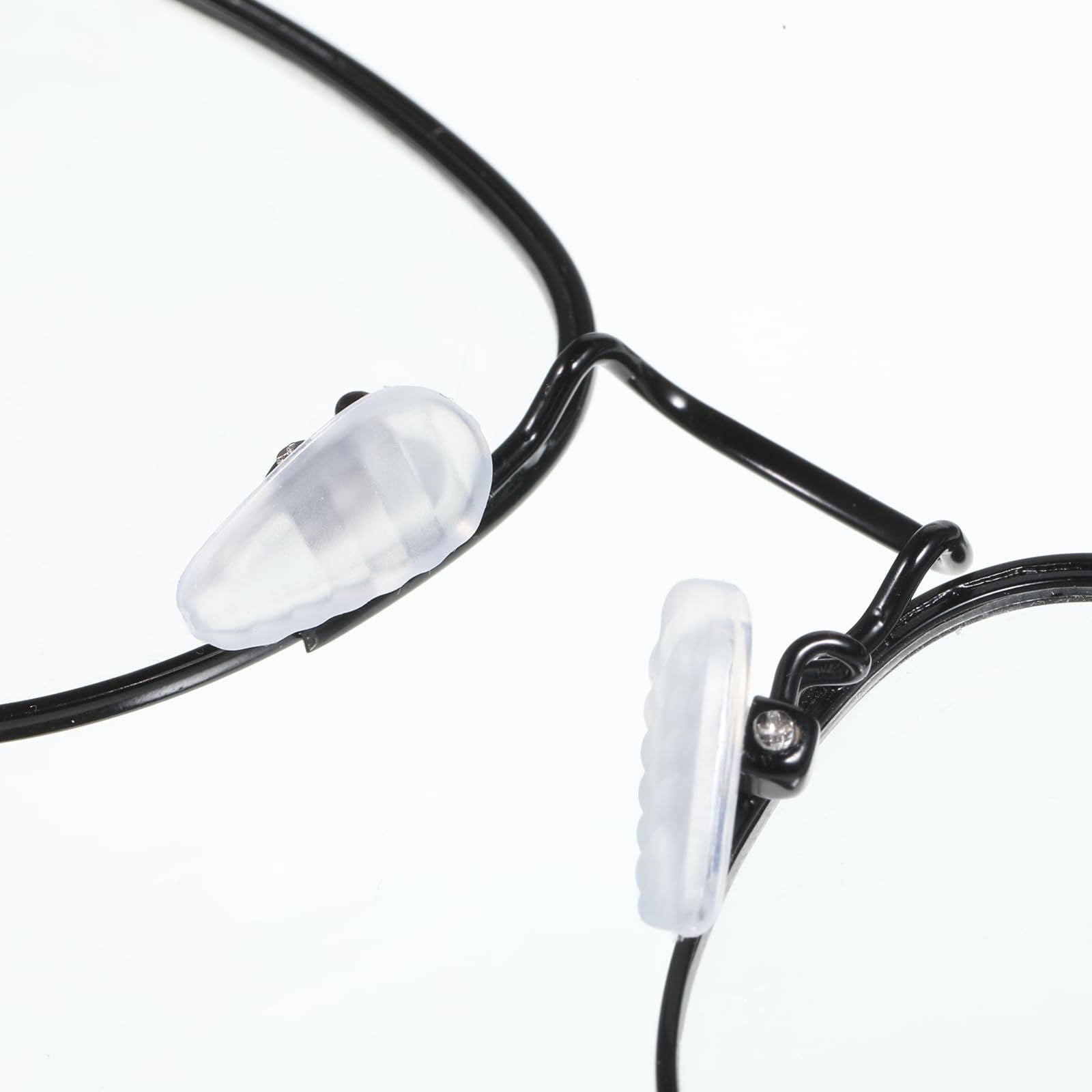 Nose pads being installed on an eyeglass frame