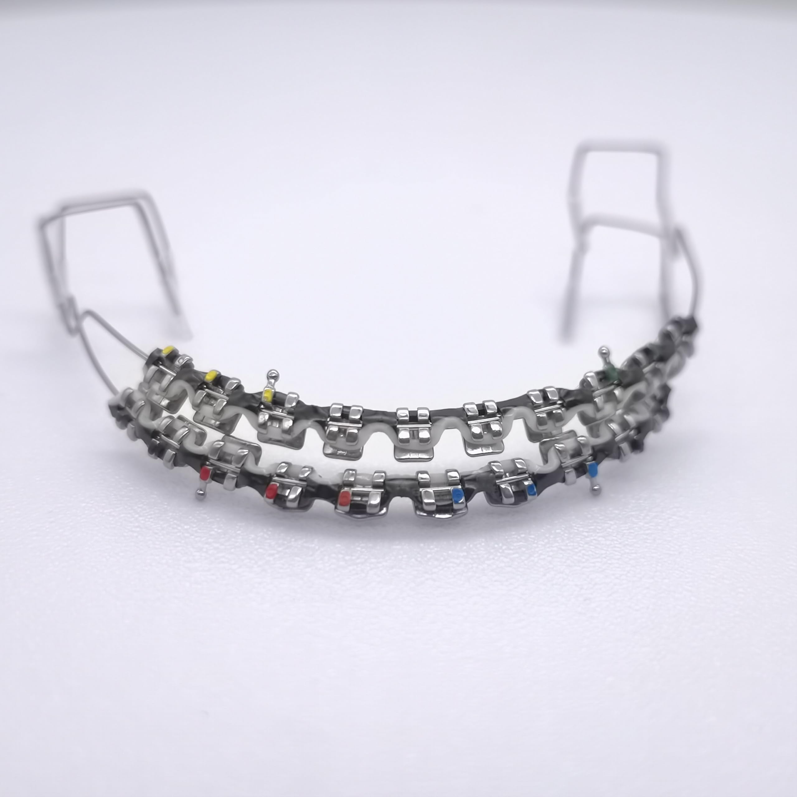 Fake braces kit showing two-color power chain on upper and lower teeth