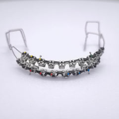 Fake braces kit showing two-color power chain on upper and lower teeth