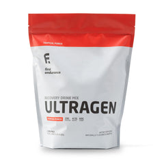 FIRST ENDURANCE Ultragen Tropical Punch powder scoop beside shaker for post-workout recovery preparation
