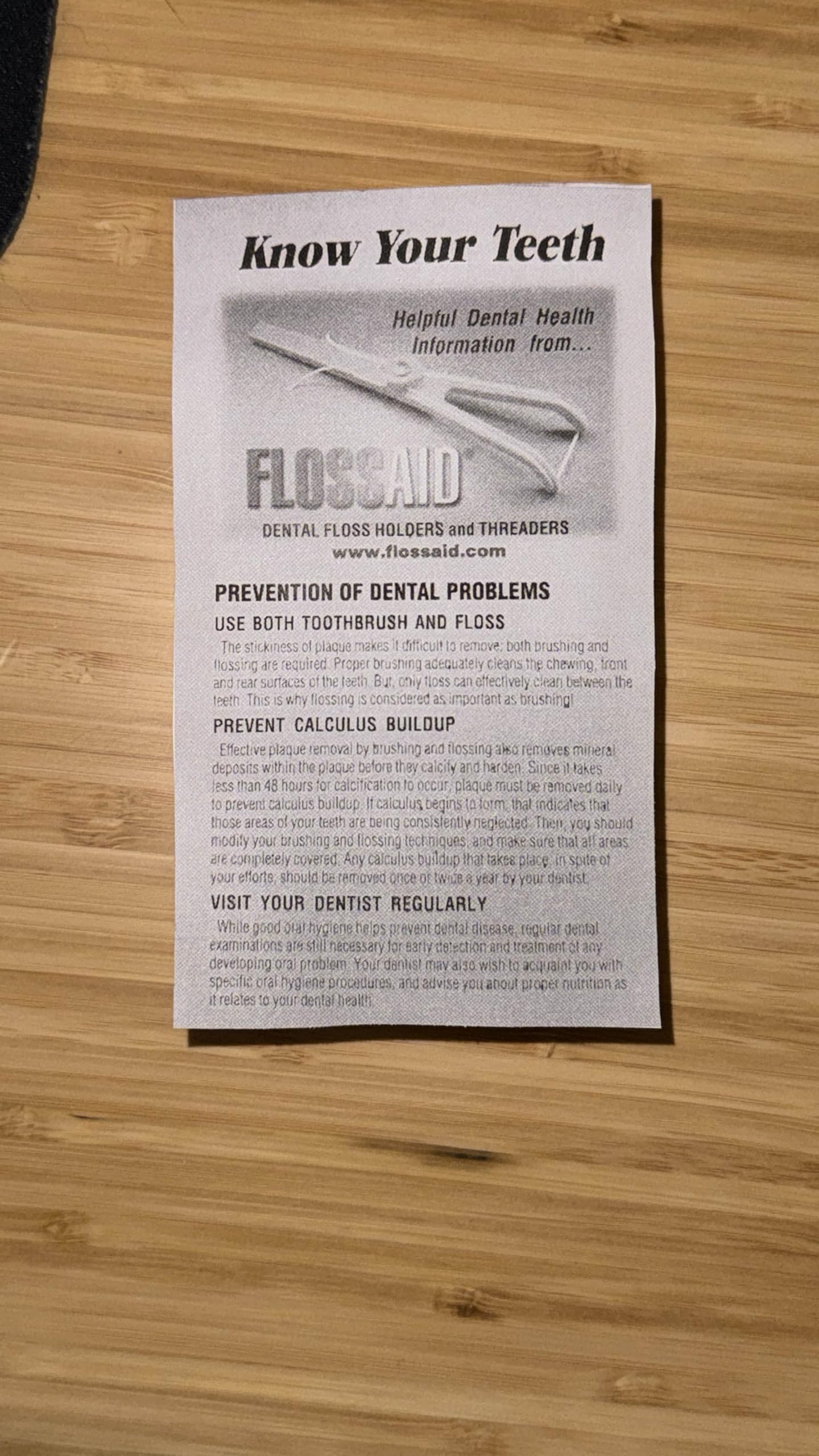 Close-up of FLOSSAID floss holder showing angled head and colors