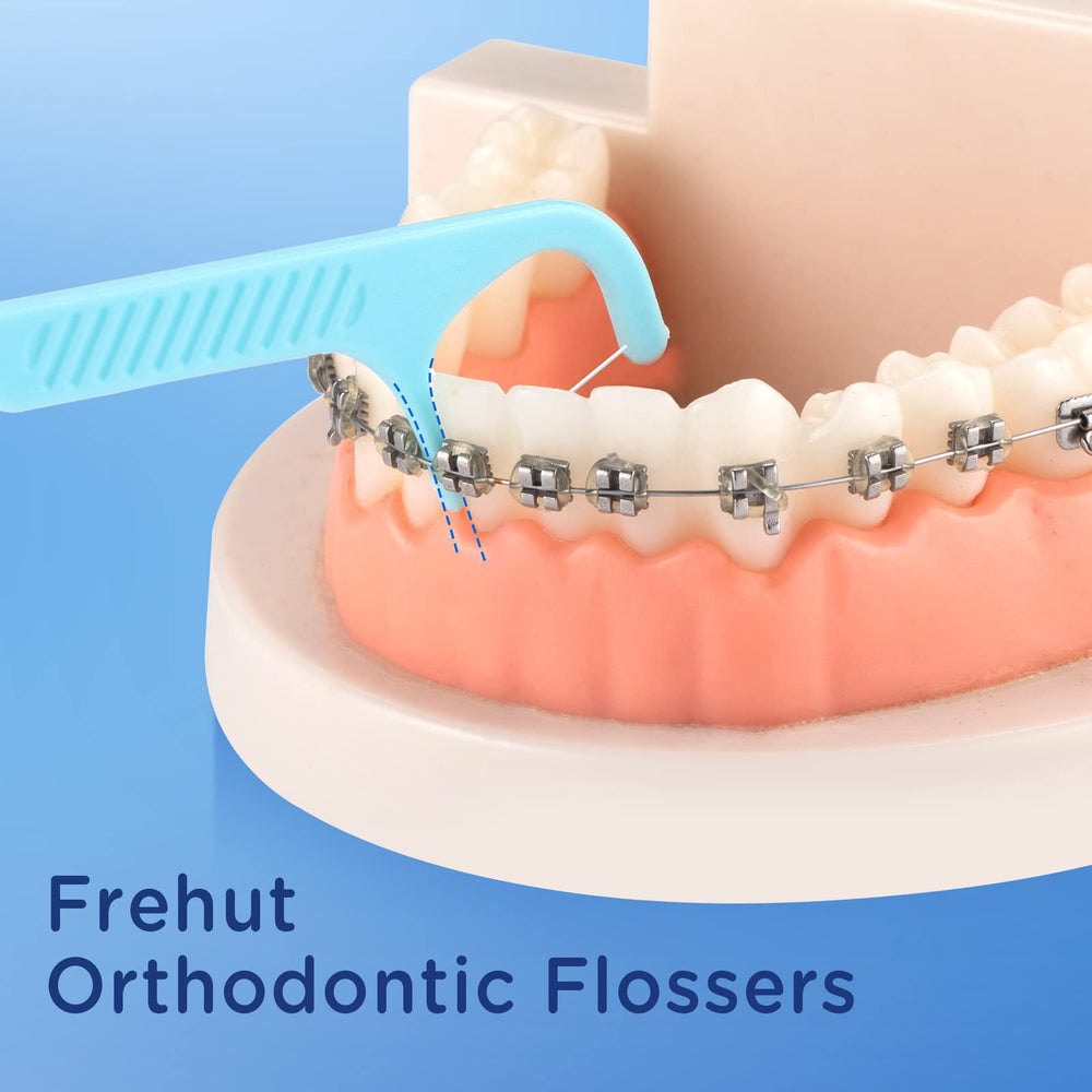 Close-up of braces floss picks showing floss between braces