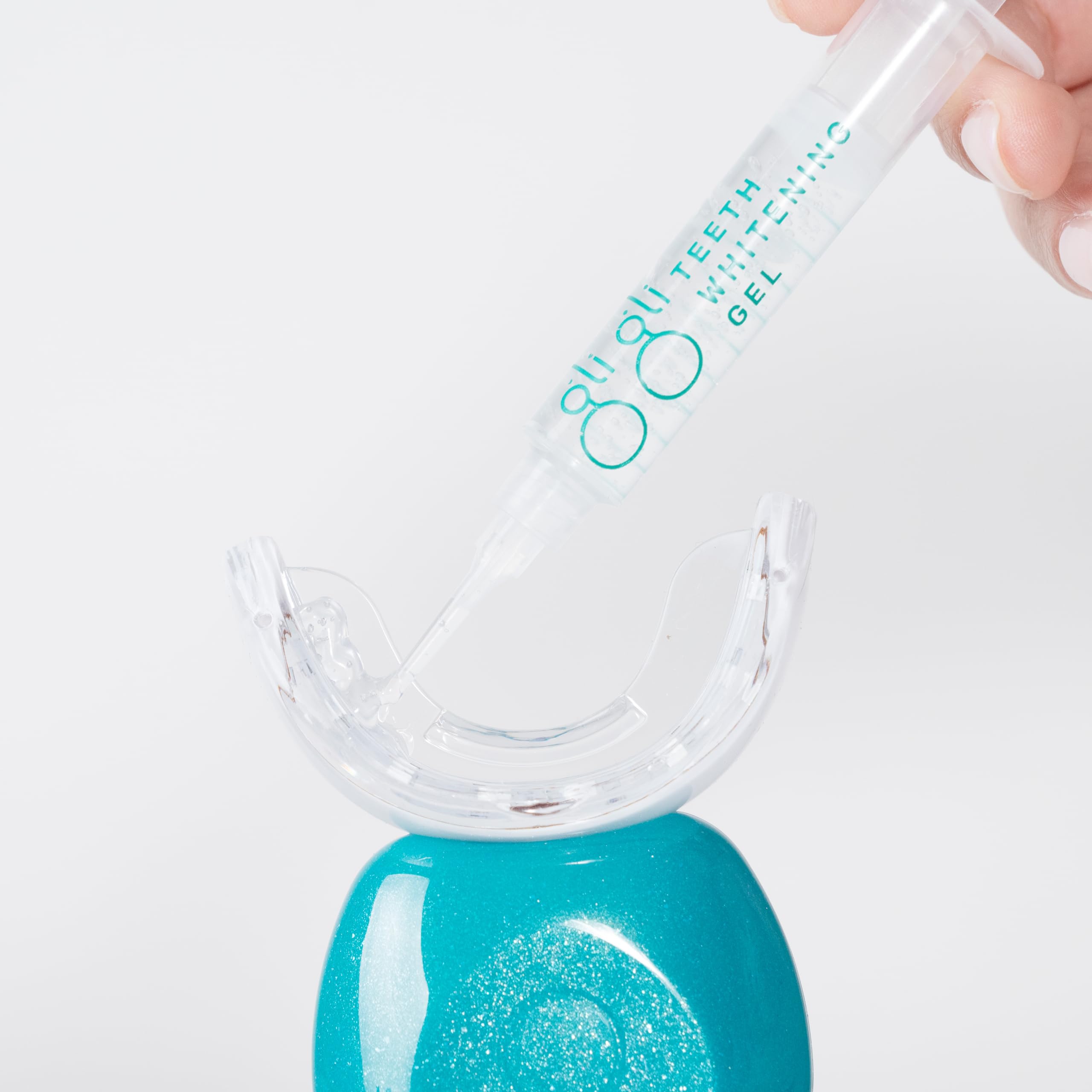Close-up of syringe tip dispensing whitening gel