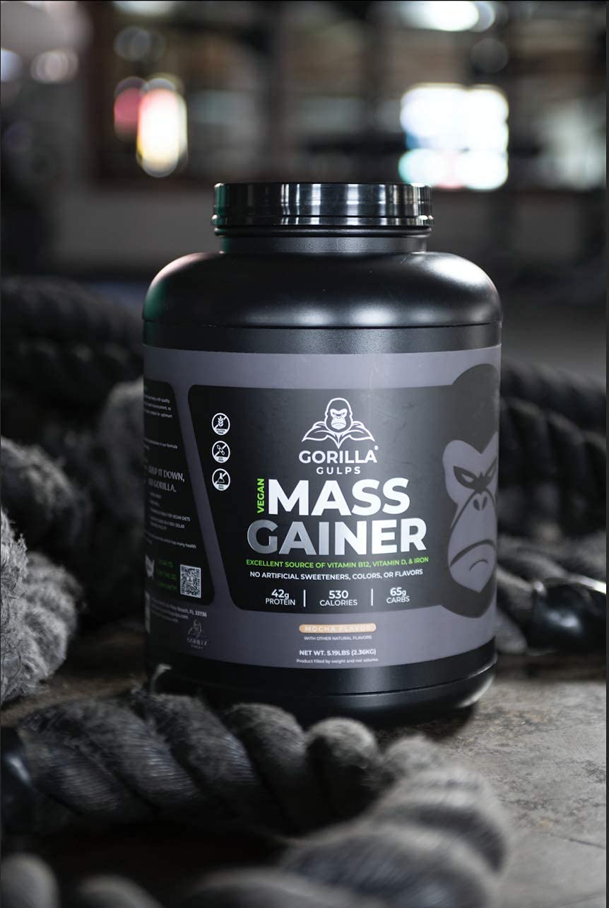 Pouring Gorilla Gulps mocha vegan mass gainer into a shaker