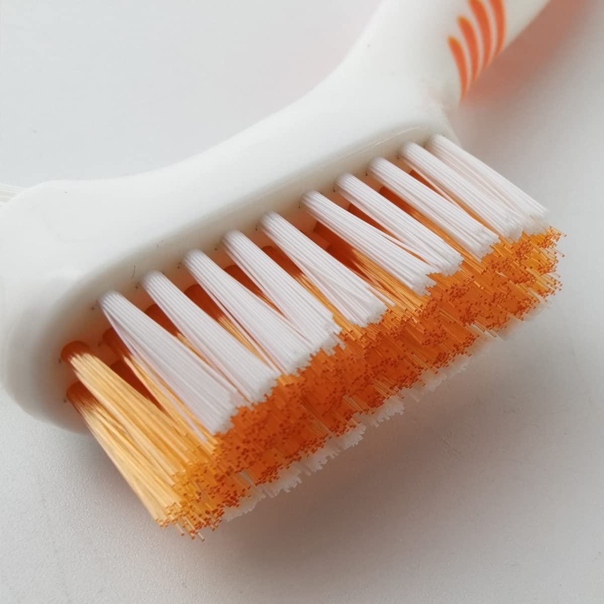 Angled brush head with multi-layered bristles for hard-to-reach areas