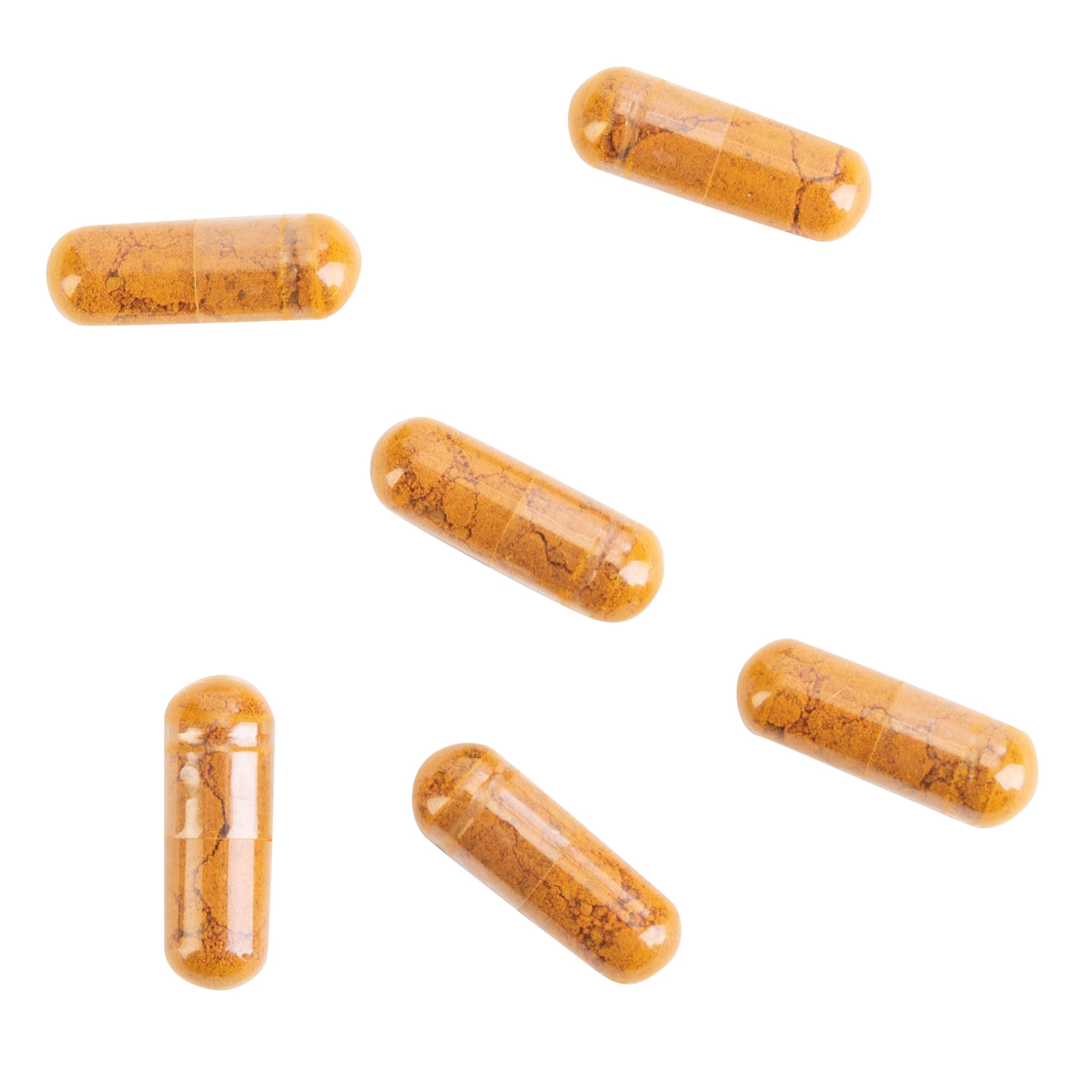 Turmeric root and capsules arranged with bottle