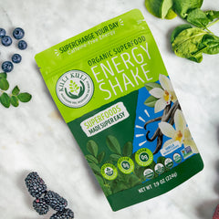 Kuli Kuli vanilla smoothie in glass with greens and protein focus.