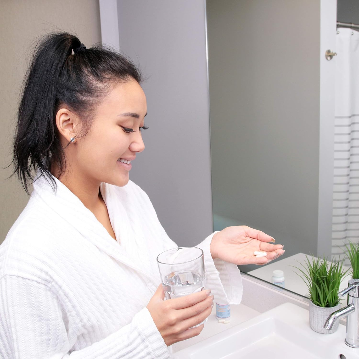 Lifestyle shot of L-Glutathione pills with glass of water