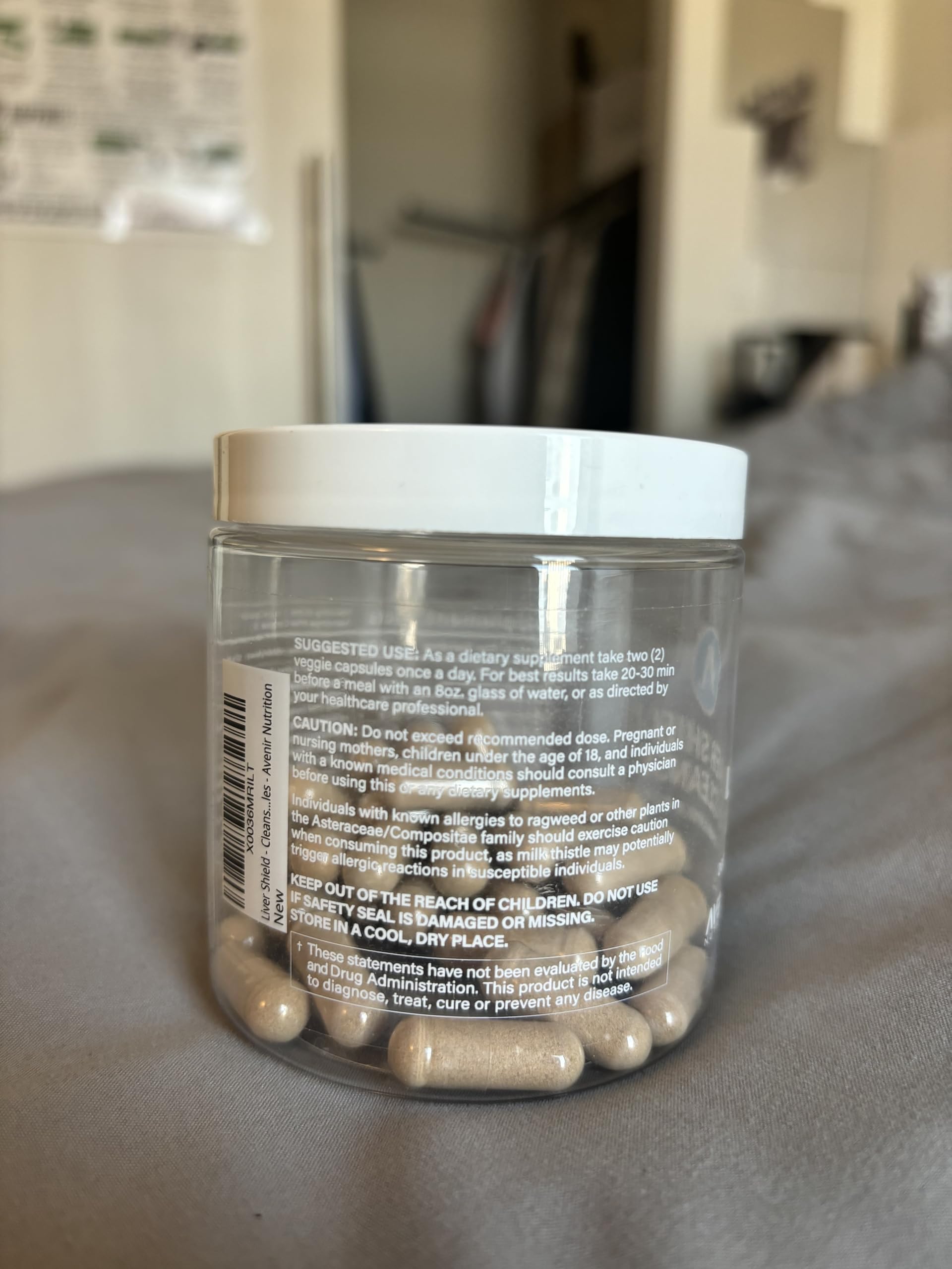Glass bottle with clear capsules on a white background