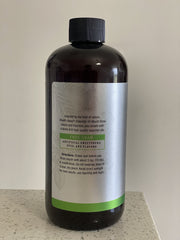 Pouring Melaleuca Breath-Away Mouth Rinse into a glass with fresh mint leaves