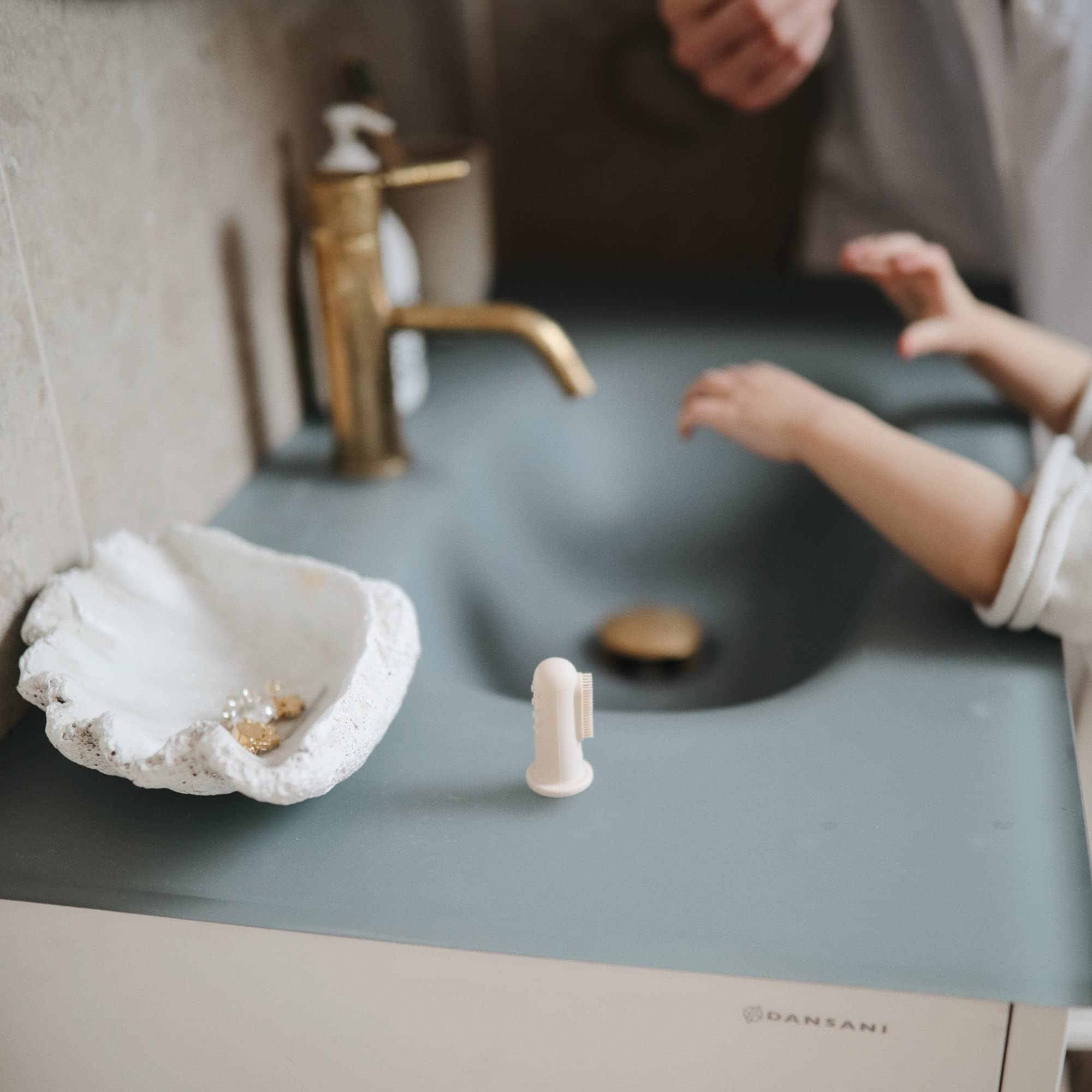 Fingertip design of Mushie finger toothbrush for gentle cleaning