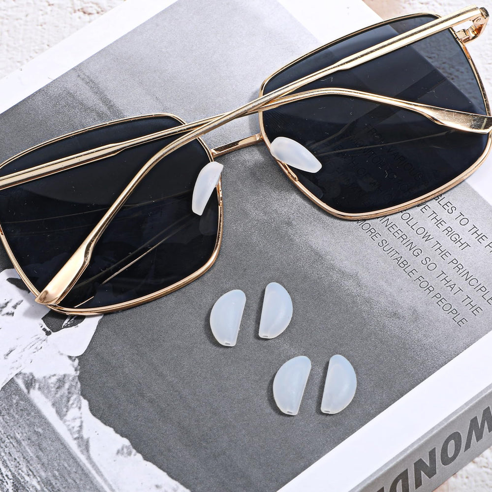 Flat lay of 10 white silicone nose pads for rimless frames