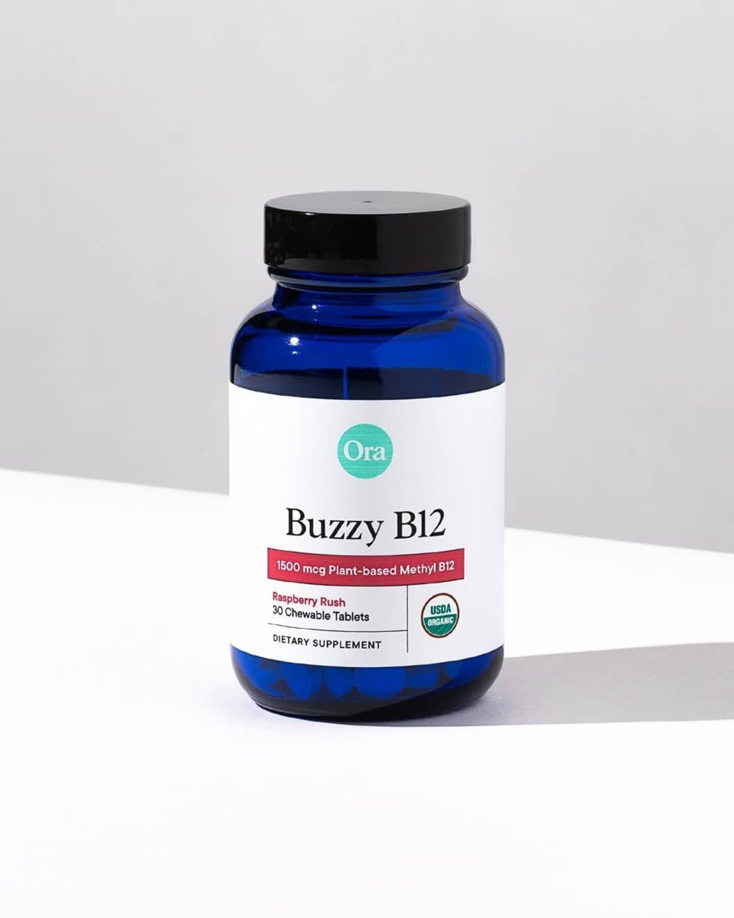 Lifestyle image of a person taking Ora Organic B12 raspberry chewable