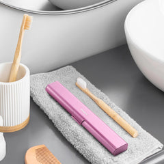 Opened pink aluminum travel case showing interior for toothbrush