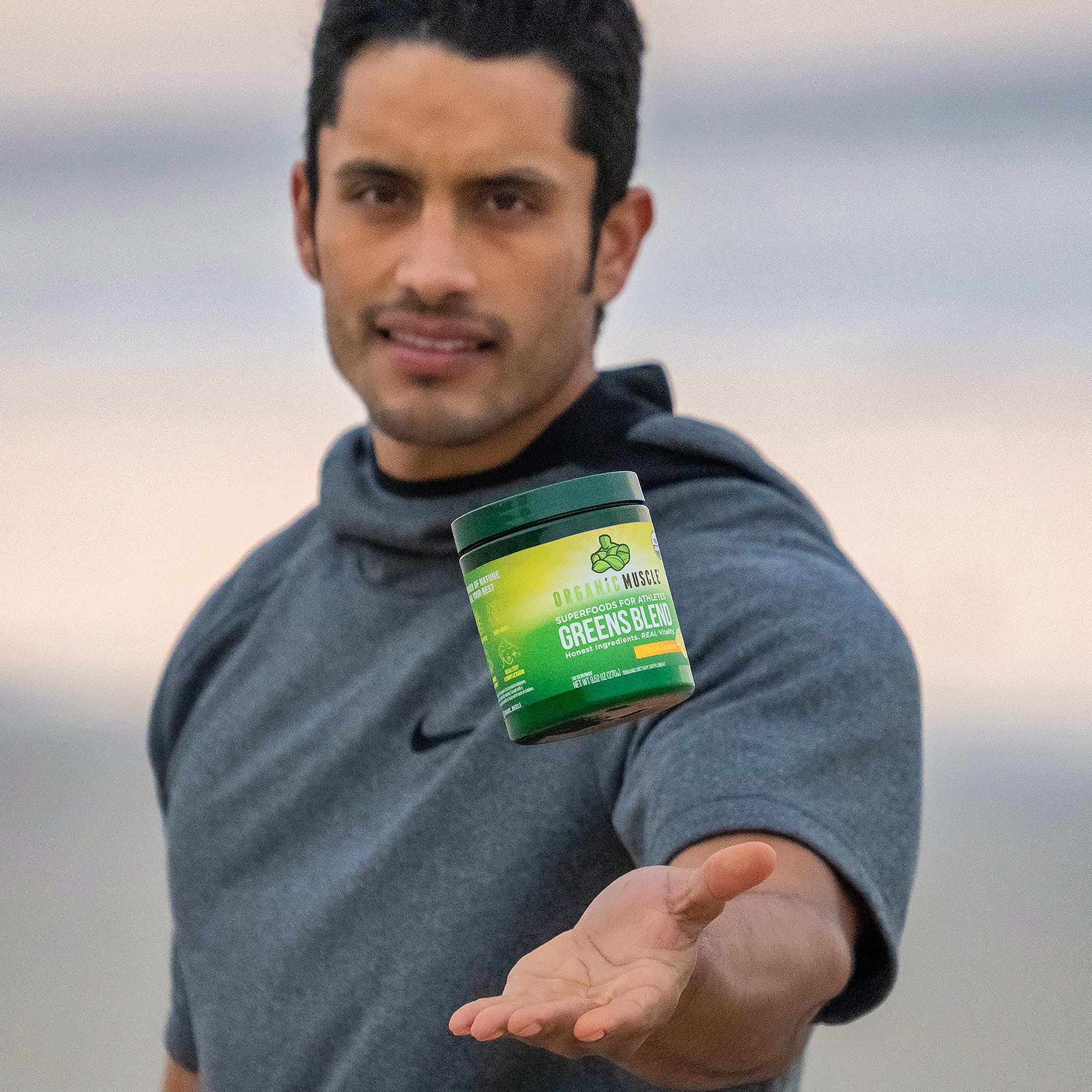 Organic Muscle Super Greens Powder mixed in water glass demonstrates quick on-the-go nutrition.