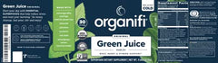 Measuring scoop with Organifi Green Juice powder over a glass of water