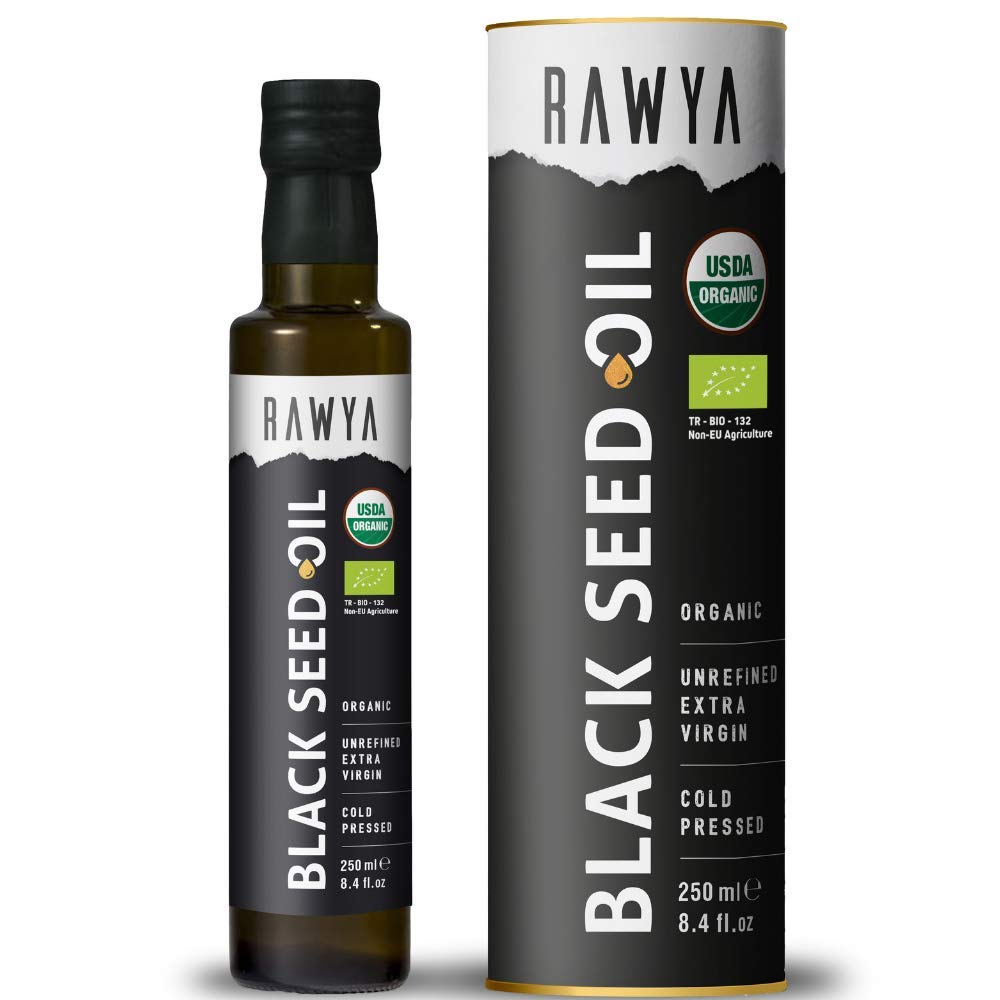 RAWYA Black Seed Oil being drizzled over a salad with bottle in background