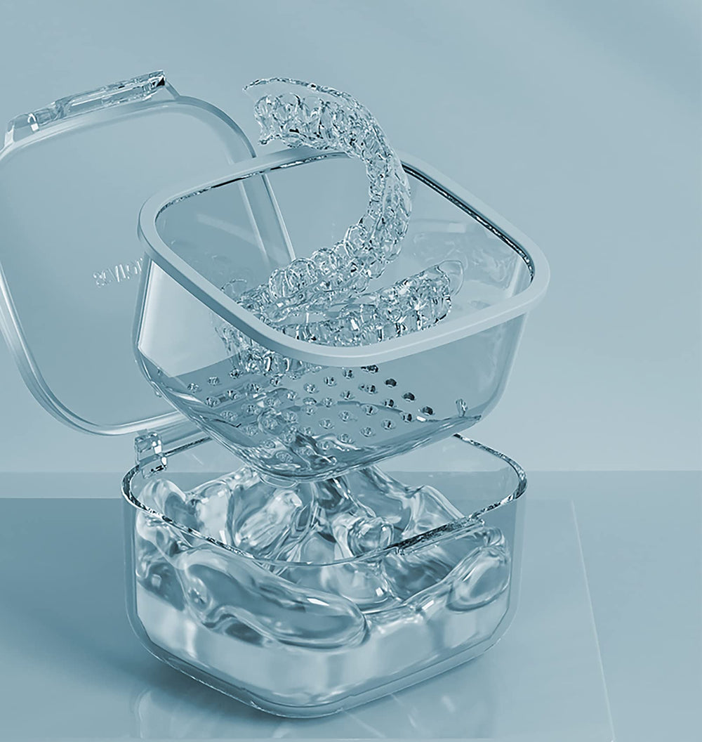 Open blue denture bath case showing drain tray