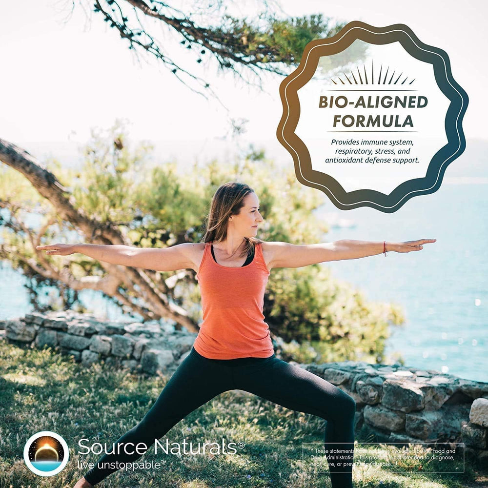 Source Naturals Wellness Formula tablets aligned with measuring spoon and glass.