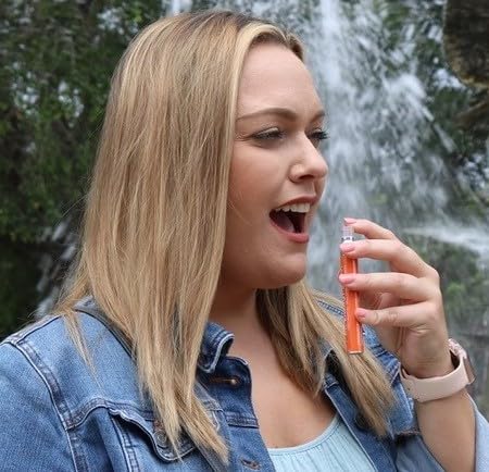 User applying Spectraspray oral spray under tongue