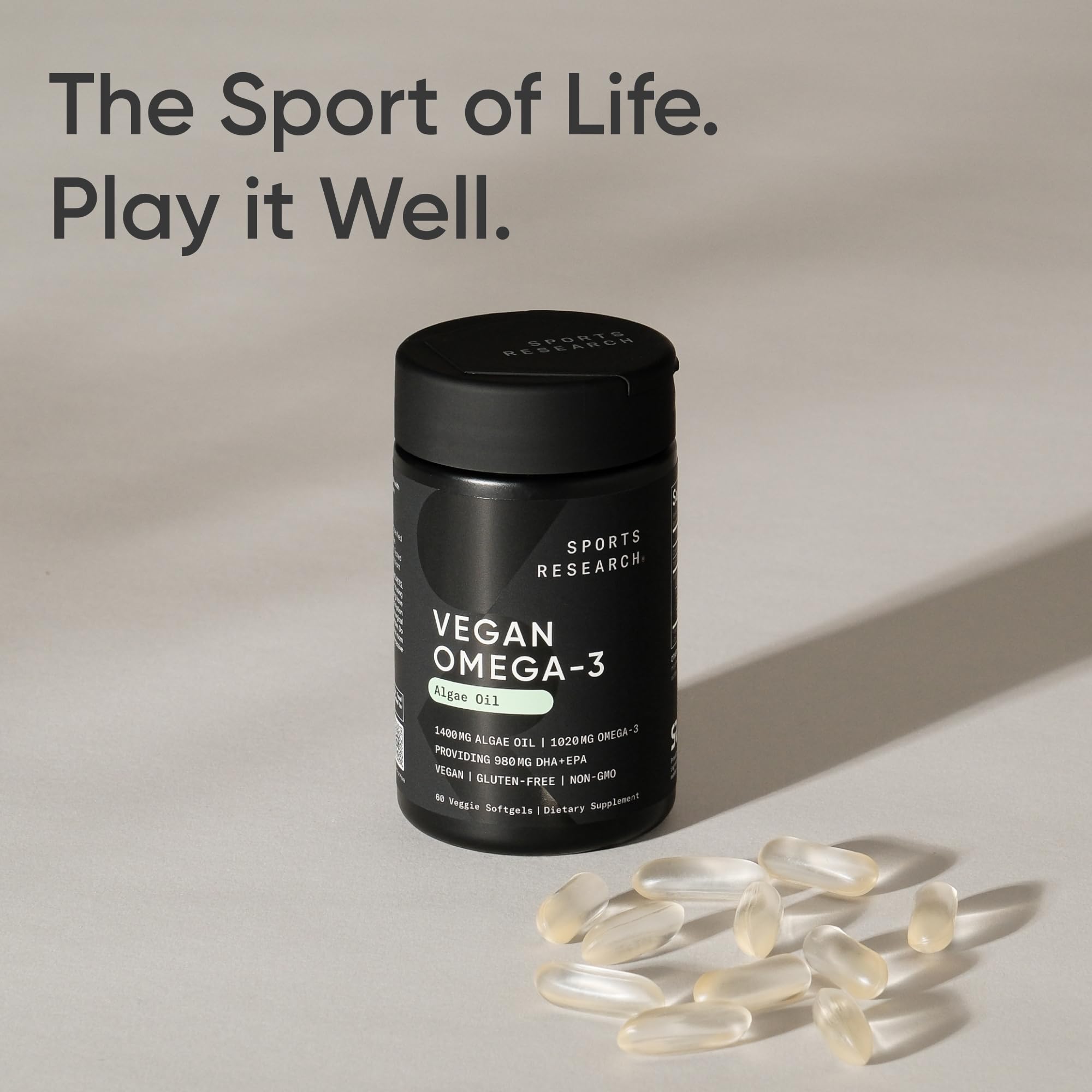 A person taking Sports Research vegan omega-3 capsule with a meal