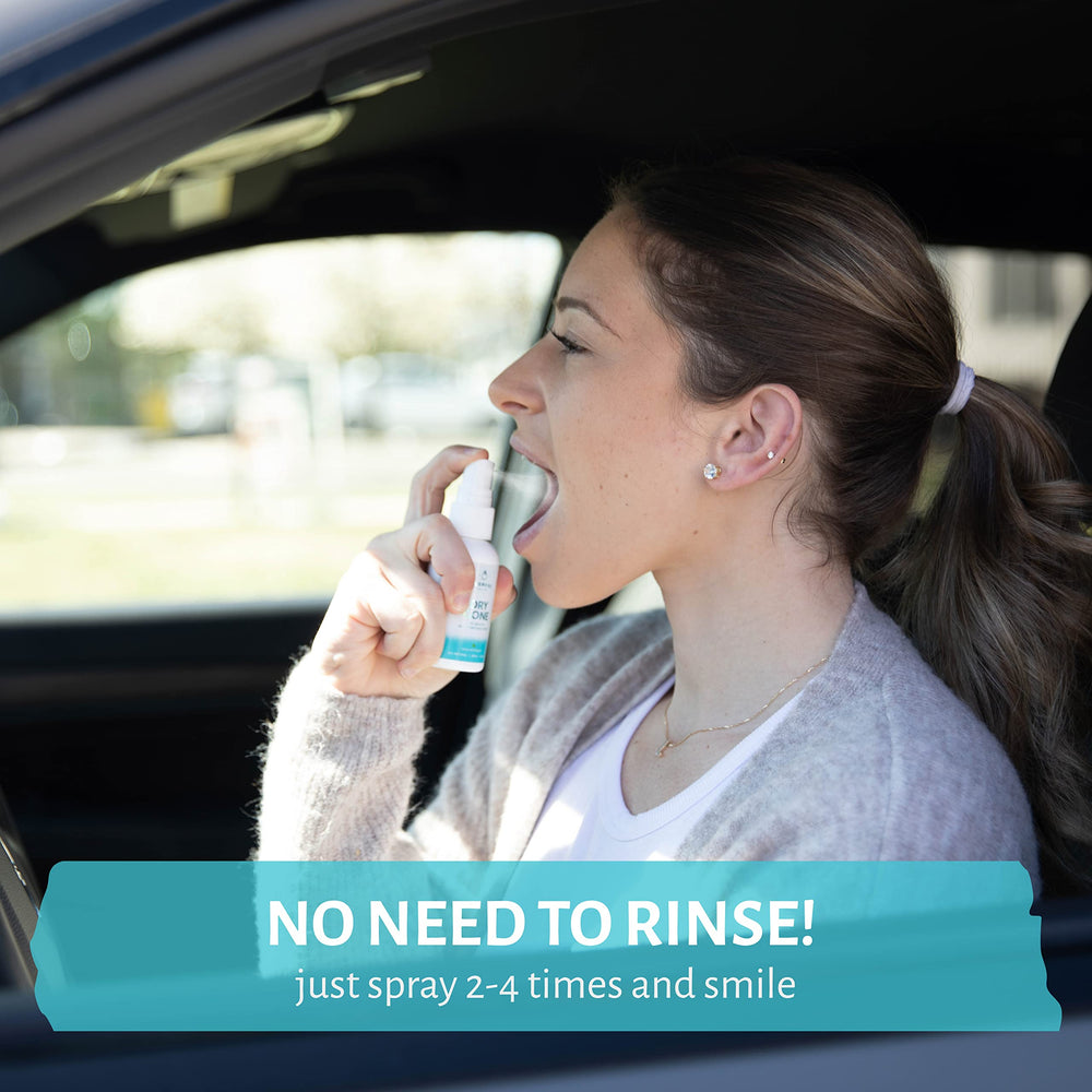 Hand holding spray bottle for dry mouth relief