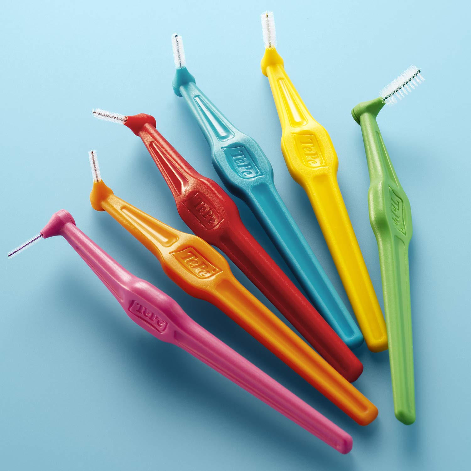 Tepe angled pink interdental brush in use between teeth
