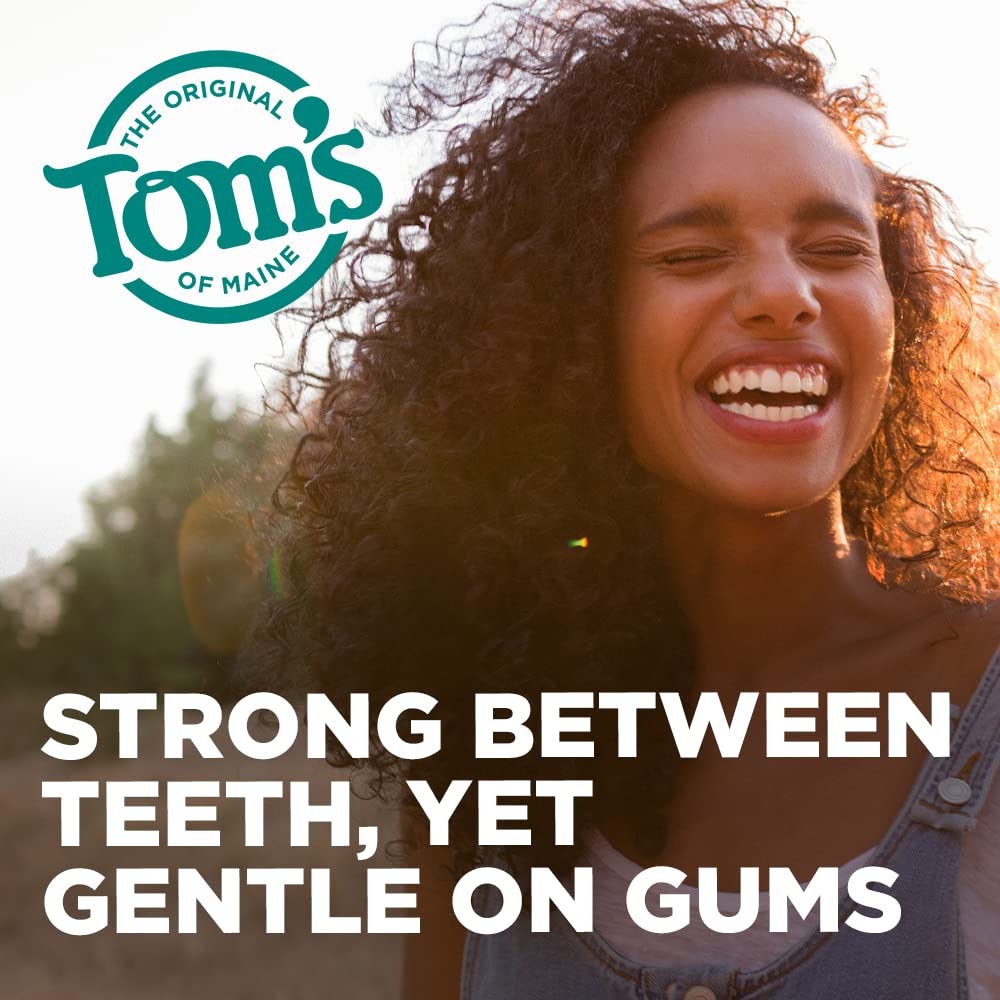 Dental floss sliding between teeth in a gentle C-shape