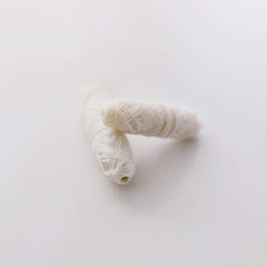Close-up of silk floss spools coated with plant-based Candelilla wax