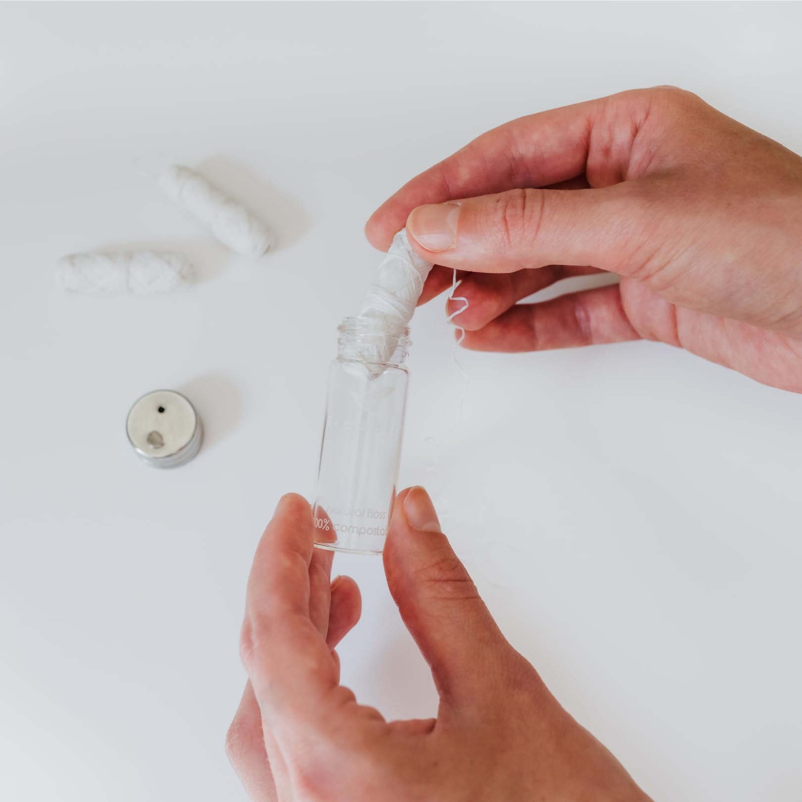 Close-up of the refillable glass floss dispenser and silk floss