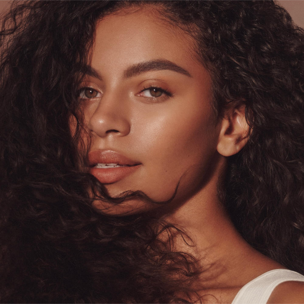 Gummies arranged in a row beside a strawberry