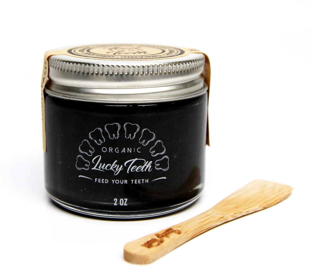 Close-up of coconut activated charcoal toothpaste in glass jar