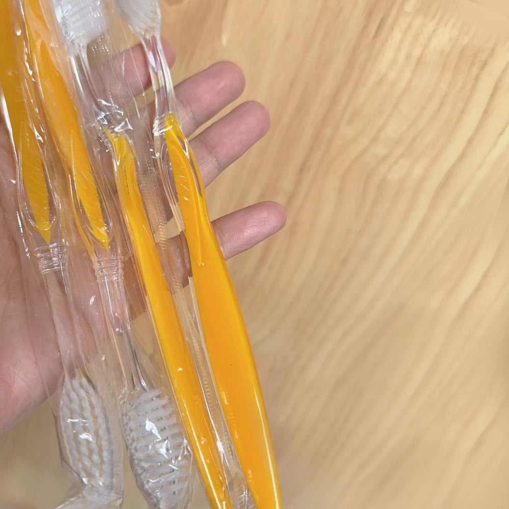 Bulk 100-pack toothbrushes arranged in a row